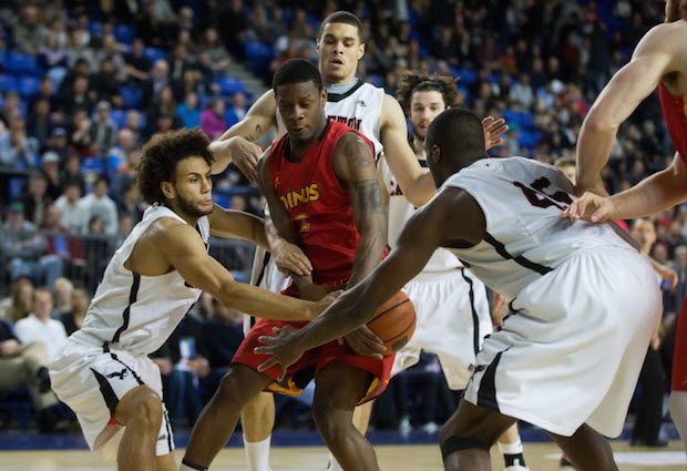 Calgary Dinos' star guard Thomas Cooper was swarmed by Carleton defenders all game as the Ravens won another national title Sunday in Vancouver. (PNG photo by Mark van Manen)