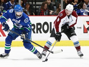 Dan Hamhuis of the Vancouver Canucks and Tyson Barrie of the Colorado Avalanche battle for the puck during their game at Rogers Arena on Feb. 21. Vancouver won 5-1. The season series continues tonight at Rogers Arena. (Photo by Jeff Vinnick/NHLI via Getty Images)