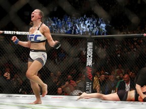Miesha Tate, left, celebrates victory over Holly Holm in their UFC 196 womens bantamweight mixed martial arts match, Saturday, March 5, 2016, in Las Vegas. (AP Photo/Eric Jamison)