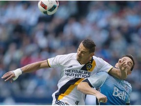 Los Angeles Galaxy’s Daniel Steres, left, prevents Vancouver Whitecaps’ Octavio Rivero from receiving a pass during the first half of an MLS soccer game in Vancouver, B.C., on Saturday April 2, 2016.