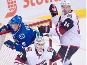 Arizona Coyotes defenceman Klas Dahlbeck tries to clear Vancouver Canucks right-winger Jake Virtanen from behind goalie Louis Domingue on Wednesday at Rogers Arena.