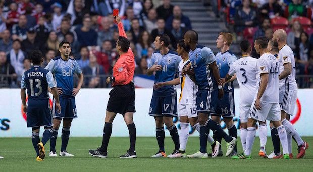 Vancouver Whitecaps' Matias Laba, second left, receives a red card from referee Jair Marrufo during the first half. 