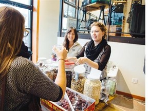 Brianne Miller, left, and volunteer Heather McIntosh serve a customer at Zero Waste Market’s pop-up store inside the Kitsilano Patagonia retail shop.