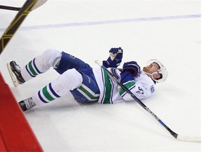 Canucks captain Henrik Sedin lies on the ice after a hit by Mikhail Grabovski of the New York Islanders, who received a boarding major for the infraction during Vancouver’s 2-1 shootout victory Sunday.