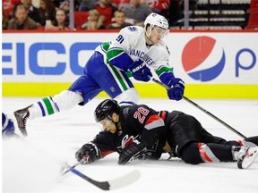 The Carolina Hurricanes’ John-Michael Liles dives in front of Canucks forward Jared McCann on Friday. McCann says he’s up for the challenge of playing on Vancouver’s top line Tuesday in his first game at Madison Square Garden.