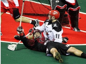 Colorado Mammoth forward Adam Jones celebrated scoring as he laid on the turf beside Calgary Roughnecks forward Greg Harnett, right, during second half NLL action at the Scotiabank Saddledome last year.