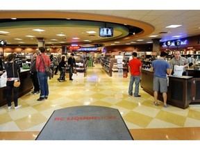 Customers pay for purchases in a liquor store in downtown Vancouver.  Union that represents government liquor store workers and association of private liquor stores says marijuana should be sold in their stores once its legal. Mark van Manen/PNG files