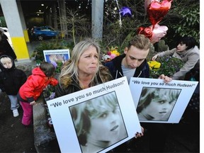 A distraught Jennifer Brooks, and son Beaudry Brooks, 22, hold pictures of her other son Hudson Brooks at a rally Sunday in Surrey near the spot where Hudson was fatally shot by RCMP on July 18, 2015.