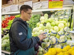 Domingo De Guzman, co-owner of the Santa Barbara Market on Commercial Drive in Vancouver, is keeping an eye on fluctuating prices for fresh produce.   Ric Ernst/PNG