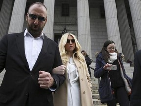 Pop star Kesha, center, leaves Supreme court in New York, Friday, Feb. 19, 2016. Kesha is fighting to wrest her career away from a hitmaker she says drugged, sexually abused and psychologically tormented her _ and still has exclusive rights to make records with her. Producer Dr. Luke says the singer is slinging falsehoods and ruining his reputation to try to weasel out of her recording contract and strike a new deal. (AP Photo/Mary Altaffer)