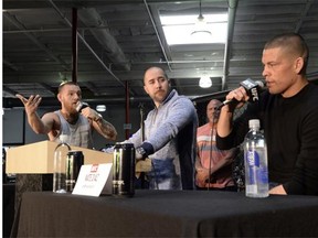 UFC featherweight champion Conor McGregor, left, and lightweight contender Nate Diaz, right, exchange pleasantries during a news conference with moderator Dave Sholler, the UFC’s vice-president of public relations, at UFC Gym in Torrance, Calif., on Wednesday.