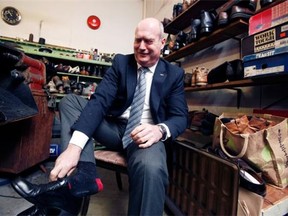 B.C. Finance Minister Mike de Jong tries on his newly soled budget dress footwear at the Olde Town Shoe Repair in Victoria on Monday. — THE CANADIAN PRESS