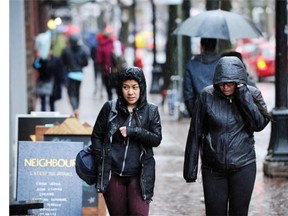Gastown shoppers try to shelter from the heavy rain Sunday, as wet weather pounds Vancouver.