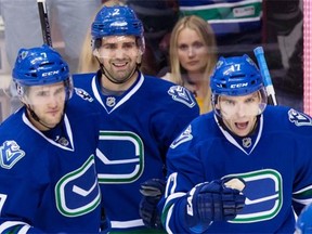Dan Hamhuis, centre, and Radim Vrbata, right, are eating up $9.5 million in salary cap space and are prime candidates to be traded if the Canucks look likely to miss the playoffs.   — The Canadian Press files