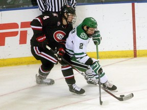 North Dakota forward Troy Stecher, right, and St. Cloud State defender Ben Storm battle for the puck during the first period of an NCAA west regional championship hockey game, Saturday, March 28, 2015 in Fargo, N.D. THE CANADIAN PRESS/AP/Bruce Crummy