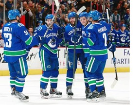 Bo Horvat, 53, Dan Hamhuis, 2, Jake Virtanen, 18 and Sven Baertschi, 47 congratulate Matt Bartkowski, 44, who scored his first goal for the Canucks against Edmonton at Rogers Arena on Oct. 18, 2015, in Vancouver. — Getty Images files