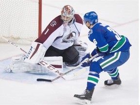Jannik Hansen scores on Colorado Avalanche goalie Semyon Varlamov, one of two goals the Vancouver Canucks right-winger had on Sunday night.