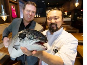 Jeremy Dunn, left, executive director of the B.C. Salmon Farmers Association and Chef Han at Kosoo Korean Kitchen and Bar, in Vancouver, display a heart-healthy salmon.   Jason Payne/ PNG