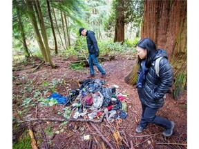 Jonathan Weissman, rear, and Annie Meneu survey a pile of trash in Stanley Park.    Ric Ernst/PNG files