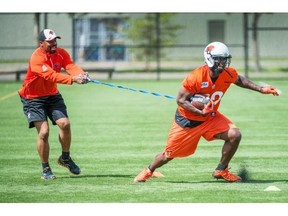 Khari Jones, pictured doing a drill with A.C. Leonard as receivers coach last season, is back in the top offensive job heading into 2016.