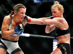 Miesha Tate, left, trades punches with Holly Holm.