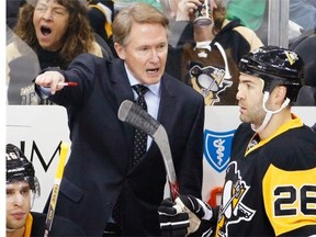 Mike Johnston, left, gives instructions to Pittsburgh’s Daniel Winnik during a 2015 NHL game. The Penguins fired Johnston as head coach in December.   — The Associated Press files