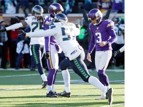 The Minnesota Vikings’ Blair Walsh, right, hangs his head as Seattle Seahawks players rejoice after the Minnesota kicker missed what would have been the winning field goal Sunday in their NFC wild-card game. The missed kick clinched a 10-9 Seattle win.    — The Associated Press