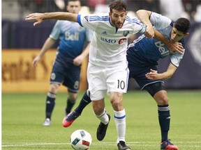 Montreal’s Ignacio Piatti holds off Matias Laba of the Vancouver Whitecaps during the Impact’s win March 6. Winless in two games, the Caps plan to address their errors Saturday when they take on the Seattle Sounders.