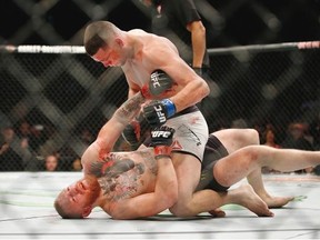 Nate Diaz, top, won his UFC 196 welterweight mixed martial arts match over Conor McGregor.   — The Associated Press