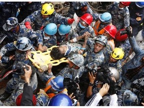 Nepalese police personnel carry an earthquake survivor on a stretcher after his rescue from a destroyed hotel building in Kathmandu in April.