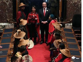 Melanie Mark, MLA elect for Vancouver-Mt Pleasant, is escorted in by B.C. NDP leader, John Horgan, during a swearing in ceremony at legislature as members of the Nisga' a First Nations play their drums on Wednesday, February 17, 2016. Melanie Mark, is the first First Nations woman serve in legislature. THE CANADIAN PRESS/Chad Hipolito