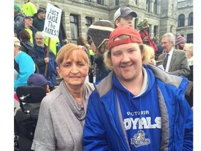Delphine Charmley and her son, Brandon, at a rally in front of the B.C. legislature. Delphine is angry the Christy Clark government is clawing back bus passes for disabled people including Brandon, 25. She is threatening to lead a class-action lawsuit against the government.