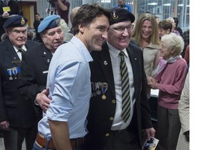 Prime Minister Justin Trudeau poses with veterans as he attends a spaghetti dinner at a local community centre in St. Andrews, N.B., on Monday, Jan. 18, 2016.
