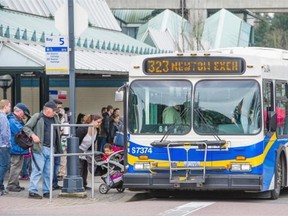 Transit users queue to board a Coast Mountain bus at the Surrey Central exchange.