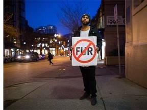 Taylor Freeman holds a sign while standing for a photograph before participating in an anti-fur protest outside a clothing store in Vancouver, B.C., on Thursday January 7, 2016. Freeman received a warning letter from Vancouver police in November that he would be charged with criminal harassment if he continued protesting outside Snowflake Furs, a different store than the one near where he was photographed. THE CANADIAN PRESS/Darryl Dyck