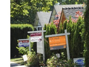 Real estate for sale signs in front of properties for sale along West 10th Avenue in Vancouver, BC Wednesday, August 15, 2012.