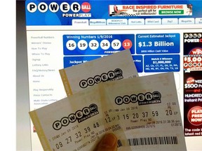 This January 10, 2016 photo illustration taken in Washington, DC, shows Powerball lottery tickets in front of the splash screen for the powerball.com website. The jackpot for the US Powerball lottery rose to a whopping $2 billion Canadian