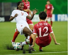 North Korea’s Jon So Yon falls as she knocks the ball away from Canada’s Nichelle Prince during second half FIFA U20 Women’s World Cup soccer action in 2014 in Montreal.
