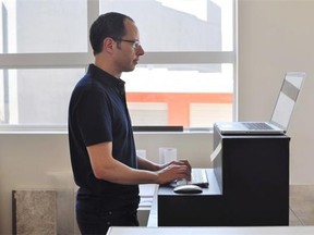 An office worker tries an Oristand desk fabricated from cardboard.