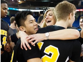 Ron Pettigrew assistant coach Dianne Tower hugs players Lance Gavino, left, and Garrett Tower after defeating Credo Christian to win the B.C. Boys Boys Single A High School Basketball Championships at the Langley Event Centre on Saturday. Dianne Tower and her son Garrett Tower, are the daughter and grandson, respectively, of Ron Pettigrew. Pettigrew and five of his players for Bethel Christian — later renamed Ron Pettigrew Christian — were killed in a fatal crash 28 years ago, on their way to the first Single A Provincial Basketball Tournament.