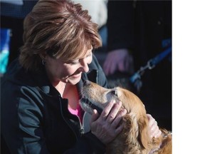 Premier Christy Clark pets a dog after an announcement about the protection of pets at the B.C. SPCA in Vancouver on Monday. B.C. expects to pass legislation next year that will include codes of practice for dog breeders, and kennel and cattery operators. — THE CANADIAN PRESS