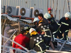 Rescue personnel carry a survivor at the site of a collapsed building in the southern Taiwanese city of Tainan following a strong 6.4-magnitude earthquake that struck the island early on February 6, 2016. At least 30 people have been rescued after four buildings collapsed after a shallow quake struck at a depth of 10 kilometres (six miles) around 2000 GMT Friday, according to the US Geological Survey, 39 kilometres northeast of Kaohsiung, the second-largest city on the island and an important port.