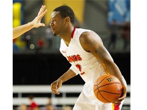 A Ryerson Ram gets his hand in the face of Thomas Cooper of the Calgary Dinos Saturday in the semifinals of the CIS Final 8 in Vancouver. Cooper scored a game-high 30 points to lead Calgary into the final.