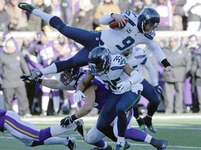 Seattle Seahawks punter Jon Ryan jumps over Minnesota Vikings linebacker Casey Matthews Sunday in Minneapolis.  — AP