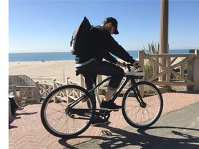 Spinlister’s chief marketing officer Andrew Batey rides one of his firm’s GPS-enabled ‘smart’ bikes.   — Spinlister