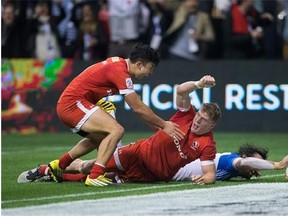 Canada's Nathan Hirayama, left, and John Moonlight, centre, celebrate after Moonlight scored the winning try in the final moments of play as France's Jean Baptiste Mazoue, right, reaches for the ball during World Rugby Sevens Series' Canada Sevens bowl final action, in Vancouver, B.C., on Sunday March 13, 2016. THE CANADIAN PRESS/Darryl Dyck