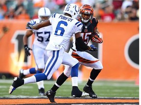 Colin Lockett runs the  ball for the Cincinnati Bengals while the Colts' Loucheiz Purifoy looks to make the tackle in 2014 NFL pre-season action. The pair are now potential B.C. Lions teammates in 2016.