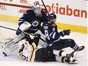 Matt Beleskey of the Boston Bruins and Jacob Trouba of the Jets collide in front of Winnipeg goaltender Michael Hutchinson in third period action at the MTS Centre in Winnipeg on Thursday night.