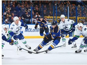 Patrik Berglund #21 of the St. Louis Blues controls the puck against Nikita Tryamkin #88, Jake Virtanen #18 and Sven Baertschi #47 of the Vancouver Canucks at the Scottrade Center on March 25, 2016 in St. Louis, Missouri.