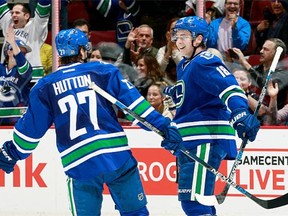 Ben Hutton #27 of the Vancouver Canucks congratulatesJake Virtanen who scored against the Ottawa Senators during their NHL game at Rogers Arena February 25, 2016 in Vancouver, British Columbia, Canada.